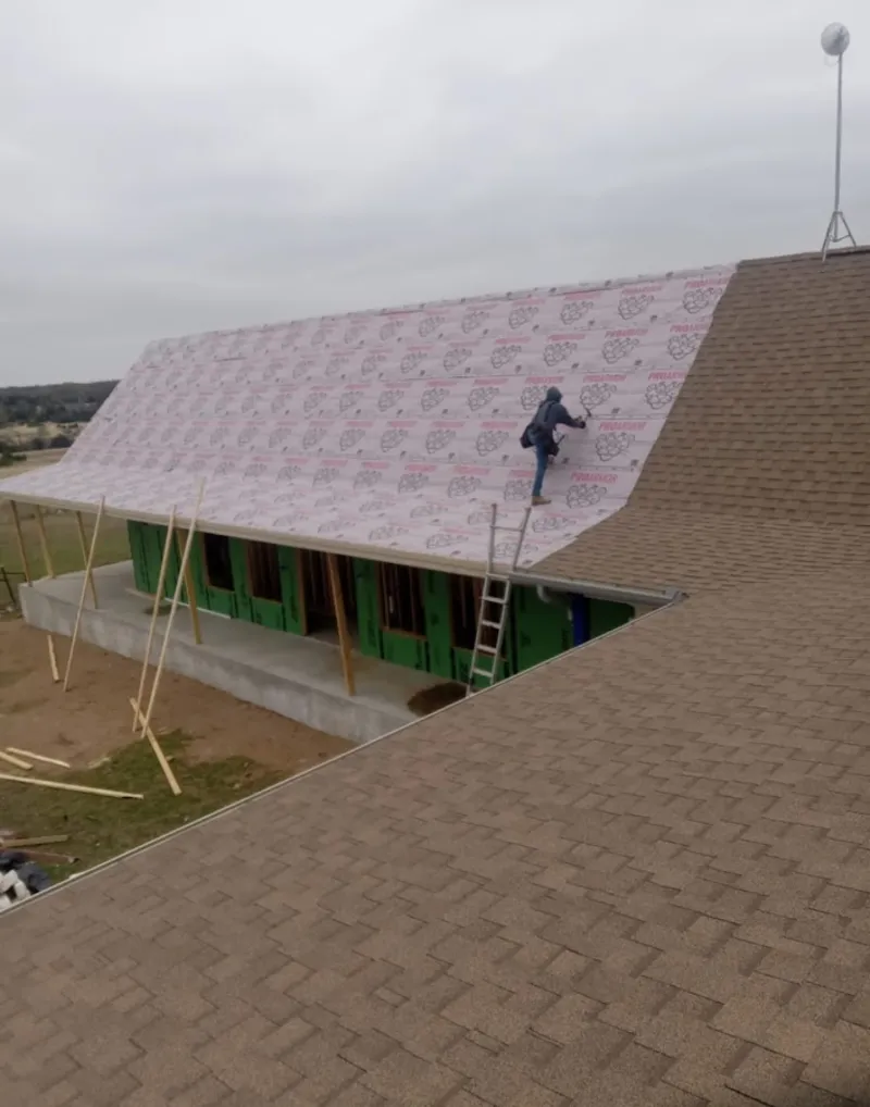 Worker preparing underlayment for a metal roof installation in Trussville
